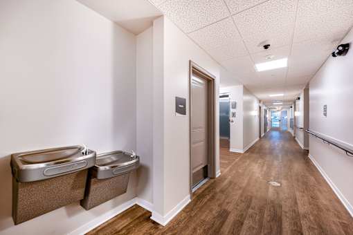 A long hallway with two trash cans on the wall.
