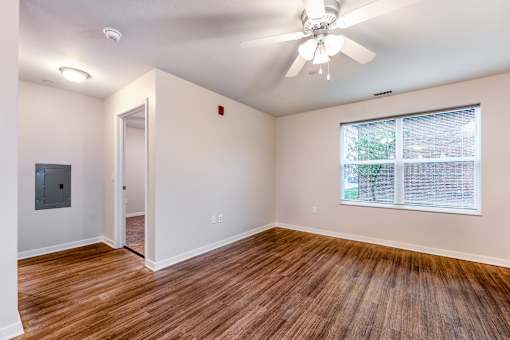 A room with a ceiling fan and a window.