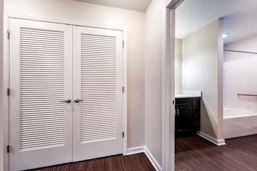 A white closet with a black wardrobe and a white door.