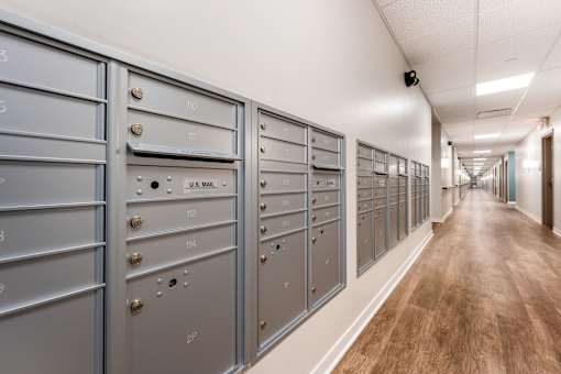 A long hallway with a row of mailboxes on the wall.