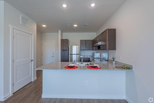 A kitchen with a white island and brown cabinets.