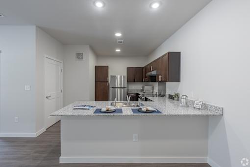 A kitchen with a white countertop and brown cabinets.