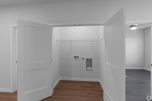 A white room with a door and a wall-mounted coat rack.