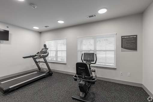 A fitness center with a treadmill and a stationary bike.