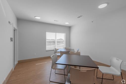 A conference room with a long table and chairs.