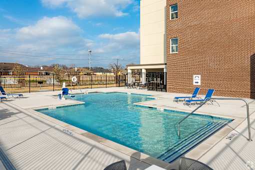 A swimming pool with blue water and a metal fence around it.