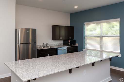 A kitchen with a granite countertop and stainless steel appliances.