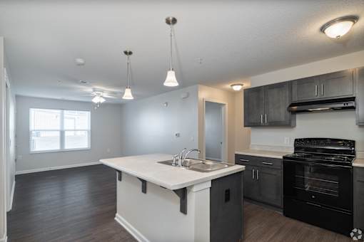 A kitchen with a black oven and a white island.
