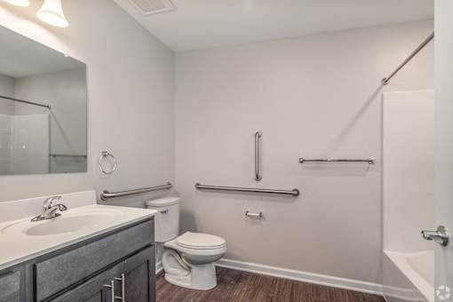 A white bathroom with a toilet, sink, and shower.