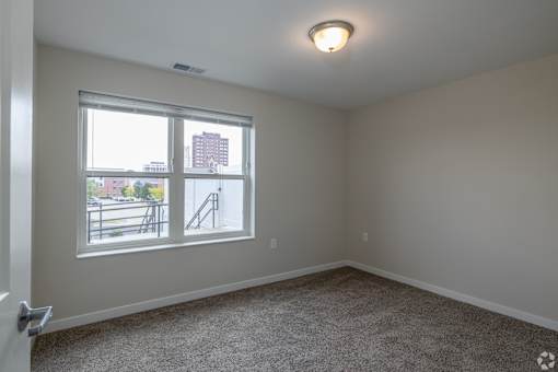 A room with a window overlooking a cityscape.