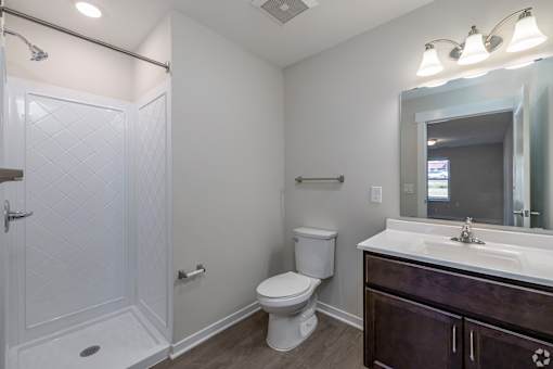 A white toilet sits next to a white sink in a bathroom.