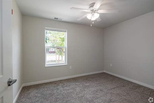 A room with a ceiling fan and a window.