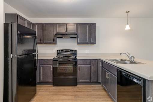 A kitchen with a black refrigerator and stove.