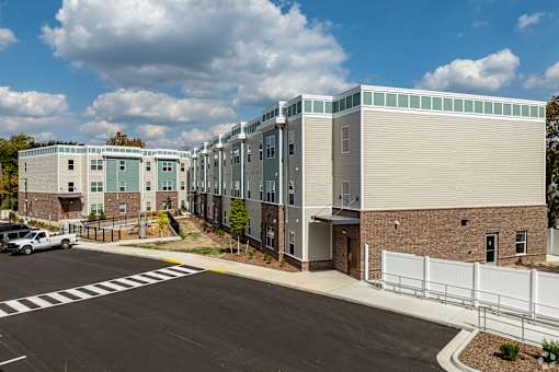 A modern building with a parking lot in front.