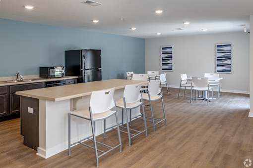A kitchen with a bar area and chairs.