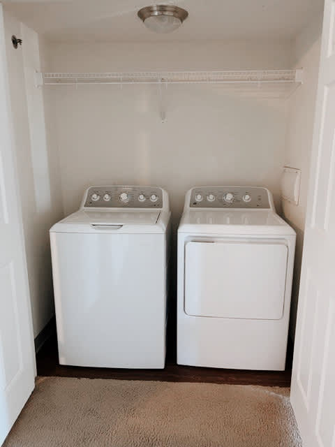Two white front loading washing machines in a small laundry room.