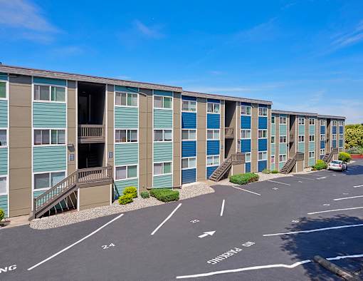 Outside apartments with numbered parking spots and well-maintained landscaping.