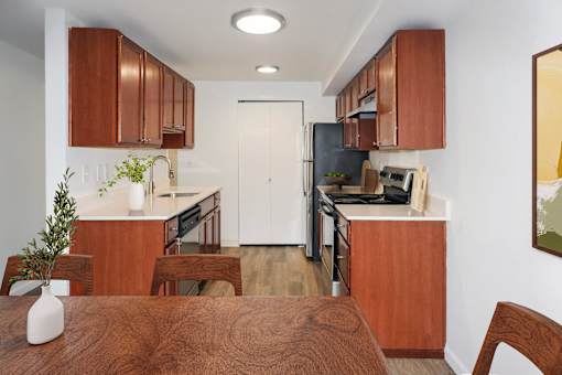 A kitchen with brown wooden cabinets and a white door at Heritage Grove Apartments in Renton, WA