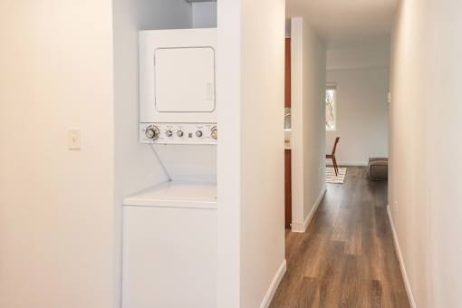 A long hallway with a washer and dryer to the left at our apartments for rent in Renton, WA