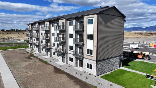 an aerial view of an apartment building with green grass and a parking lot at Yellowstone Landing, Belgrade, MT, 59714