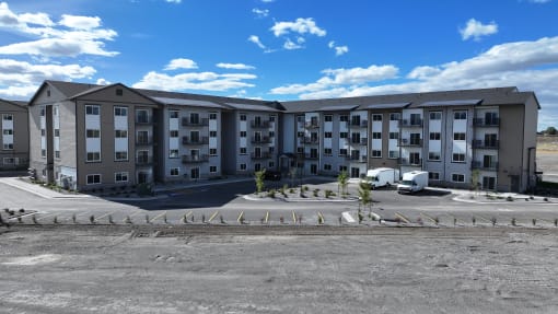 a large apartment building sitting in a parking lot at Yellowstone Landing, Belgrade, MT, 59714