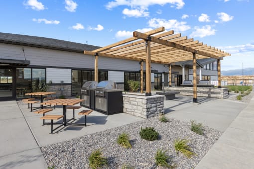 a patio with picnic tables and a grill in front of a building at Yellowstone Landing, Belgrade, MT, 59714