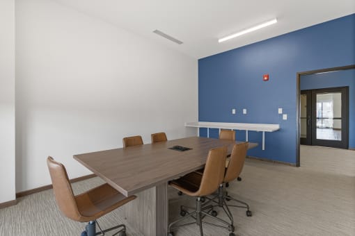 a conference room with a wooden table and chairs and a blue wall at Yellowstone Landing, Belgrade, 59714