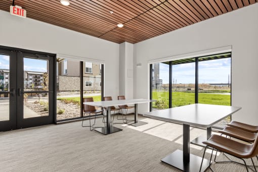a dining room with a table and chairs in a building with glass doors at Yellowstone Landing, Belgrade, 59714