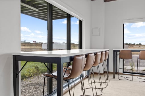 a dining table with chairs in front of a large window at Yellowstone Landing, Montana