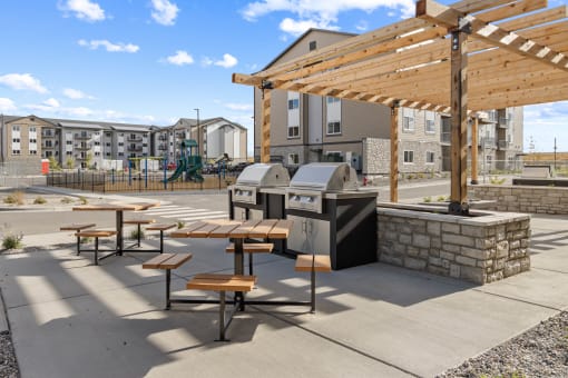 a picnic area with tables and a grill in front of a building at Yellowstone Landing, Belgrade
