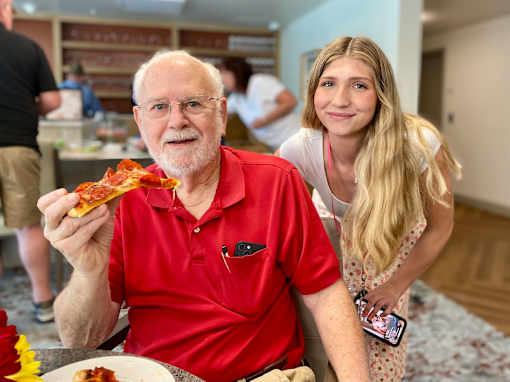 A man is eating pizza at Hearthstone Lodge Senior Residences, California, 95602