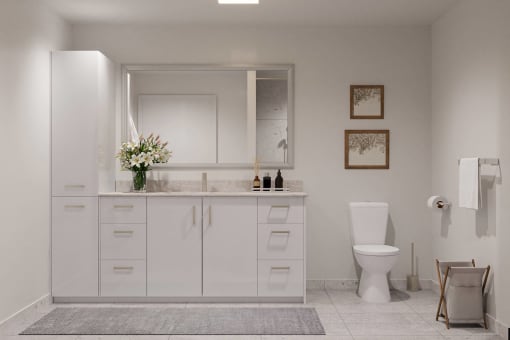 a white bathroom with a toilet and a sink at Hearthstone Lodge Senior Residences, California, 95602