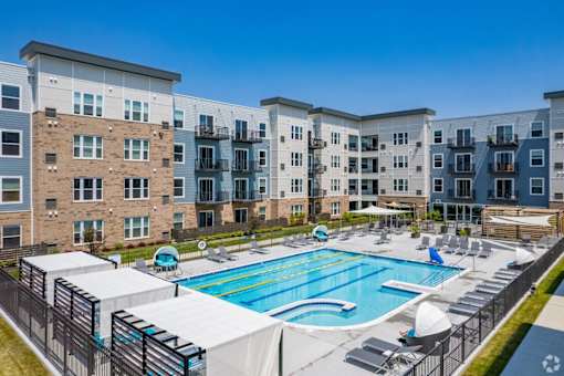 an outdoor swimming pool with an apartment building in the background