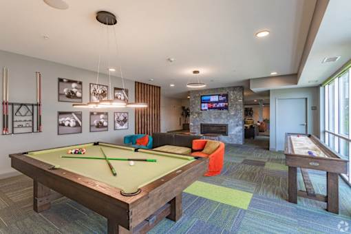 a games room with a pool table and a tv