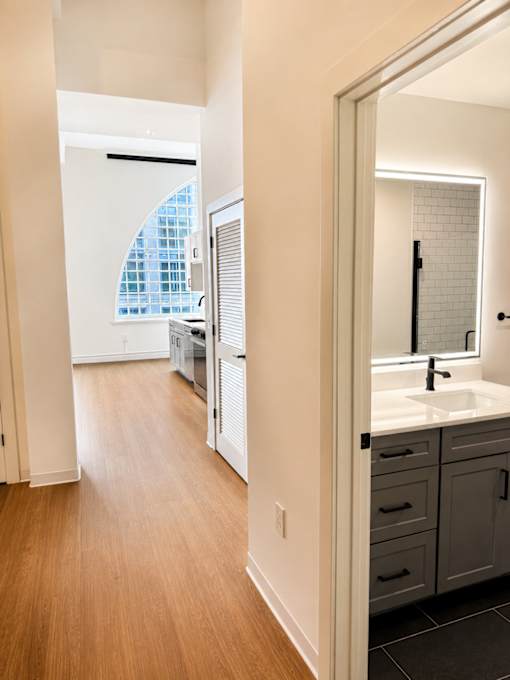 Hallway view to kitchen and bathroom vanity at Textile Lofts Apartments, Cincinnati, OH
