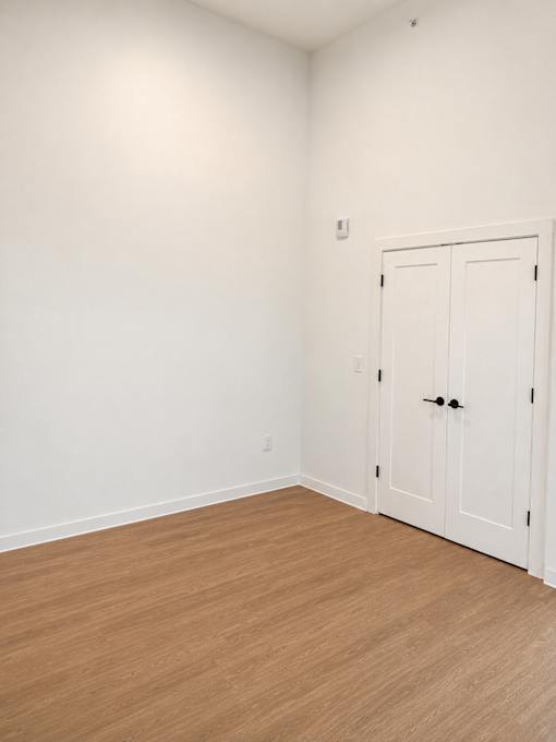 Empty bedroom with wood flooring and double doors at Textile Lofts Apartments, Cincinnati, 45202
