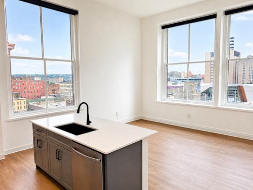 Studio apartment with kitchen island and city views at Textile Lofts Apartments, Cincinnati