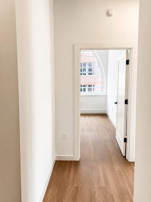 Hallway leading to bright windowed room at Textile Lofts Apartments, Ohio