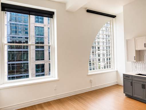 Empty studio with large windows and hardwood floors at Textile Lofts Apartments, Cincinnati, OH 45202