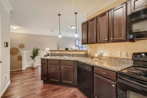 a kitchen with wooden cabinets and a counter top  at Grand Villas Apartments, Texas