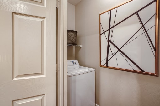 a small closet with a mirror and a washer and dryer in a bathroom at Grand Villas Apartments, Texas