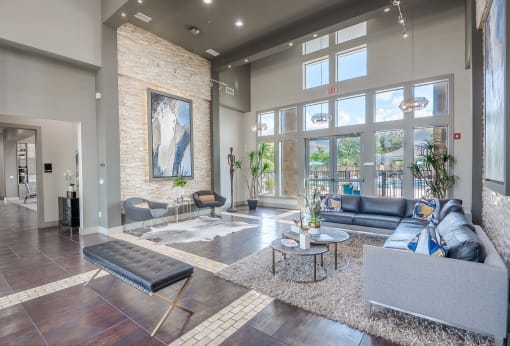 a living room with couches and tables and large windows at Discovery at Craig Ranch, McKinney, Texas