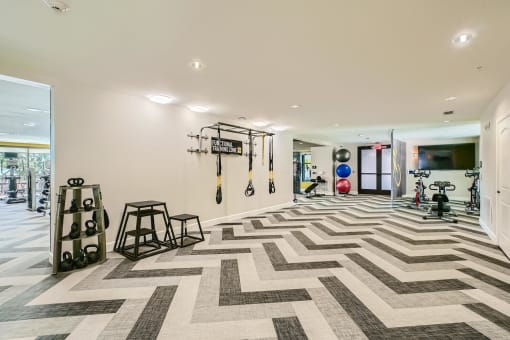 the gym in the house has a checkered floor and weights on the wall at Imperial Lofts, Sugar Land, Texas
