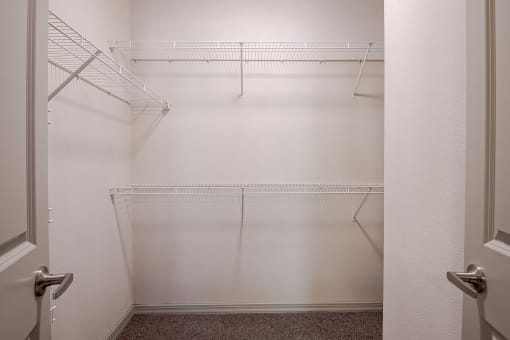 a walk in closet with empty shelves in a white room at Discovery at Craig Ranch, McKinney, Texas