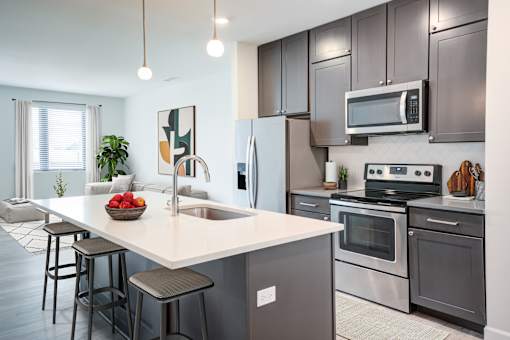 A modern kitchen with a large island and stainless steel appliances. at The MK, Indianapolis, IN, 46220