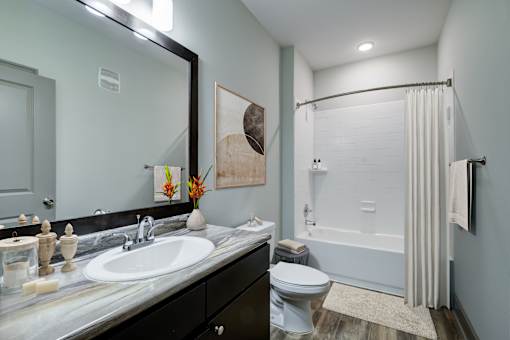 A bathroom with a white sink, toilet, and bathtub.