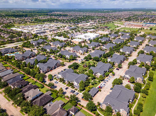A suburban neighborhood with houses and a parking lot at Avenues at Shadow Creek Ranch Apartments, Pearland, TX