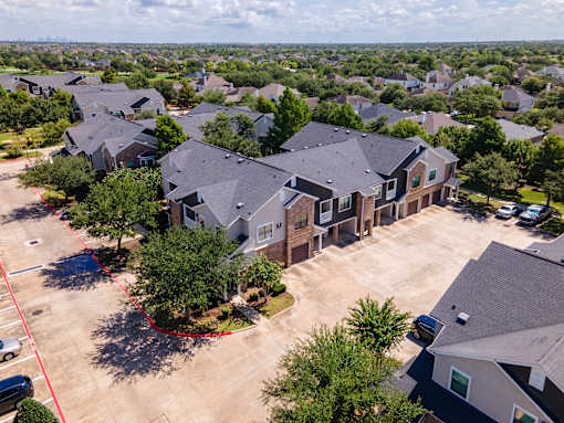 A bird's eye view of a residential area with houses and trees at Avenues at Shadow Creek Ranch Apartments, Pearland