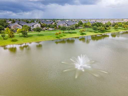 A fountain in the middle of a lake in a residential area at Avenues at Shadow Creek Ranch Apartments, Pearland, 77584