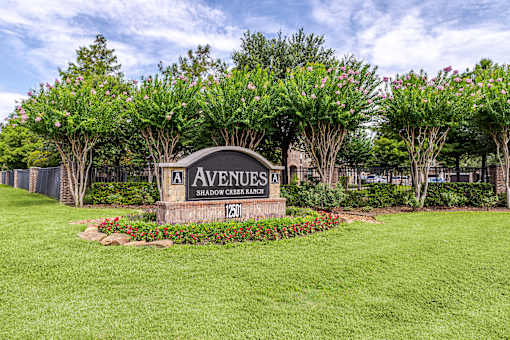 A sign that says Avenues in front of some trees at Avenues at Shadow Creek Ranch Apartments, Pearland, 77584